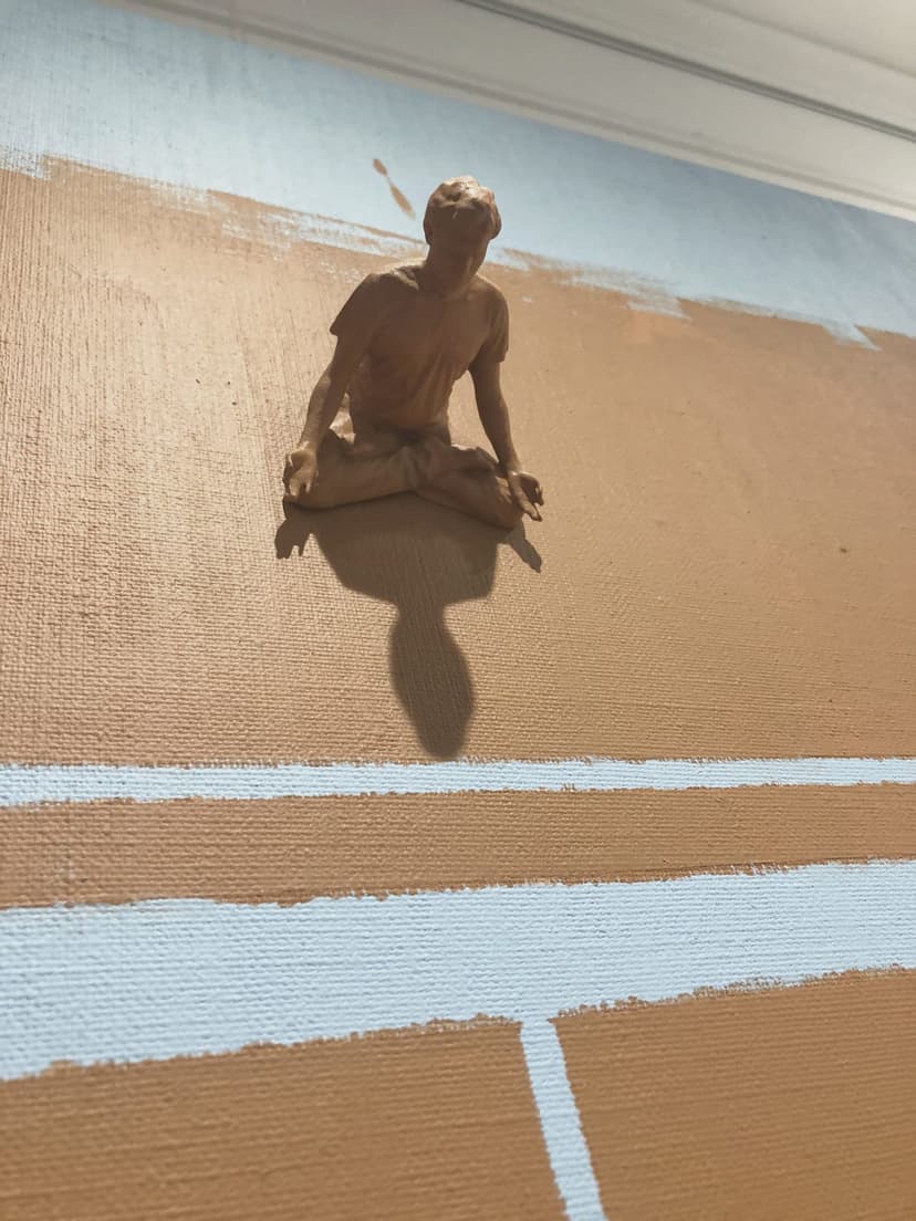 Close-up of Background by Federico Clapis: the ochre nylon powder figure meditating on the painted canvas, casting a long shadow