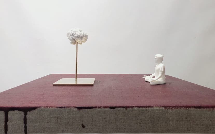 Side view of Levitation by Federico Clapis: meditating white figure and a cloud on a thin bronze stand atop a red-painted canvas