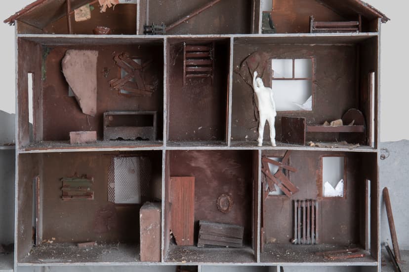 Closer view of Memories House by Federico Clapis: abandoned rooms with torn wallpaper, a radiator and the white figure touching a wall