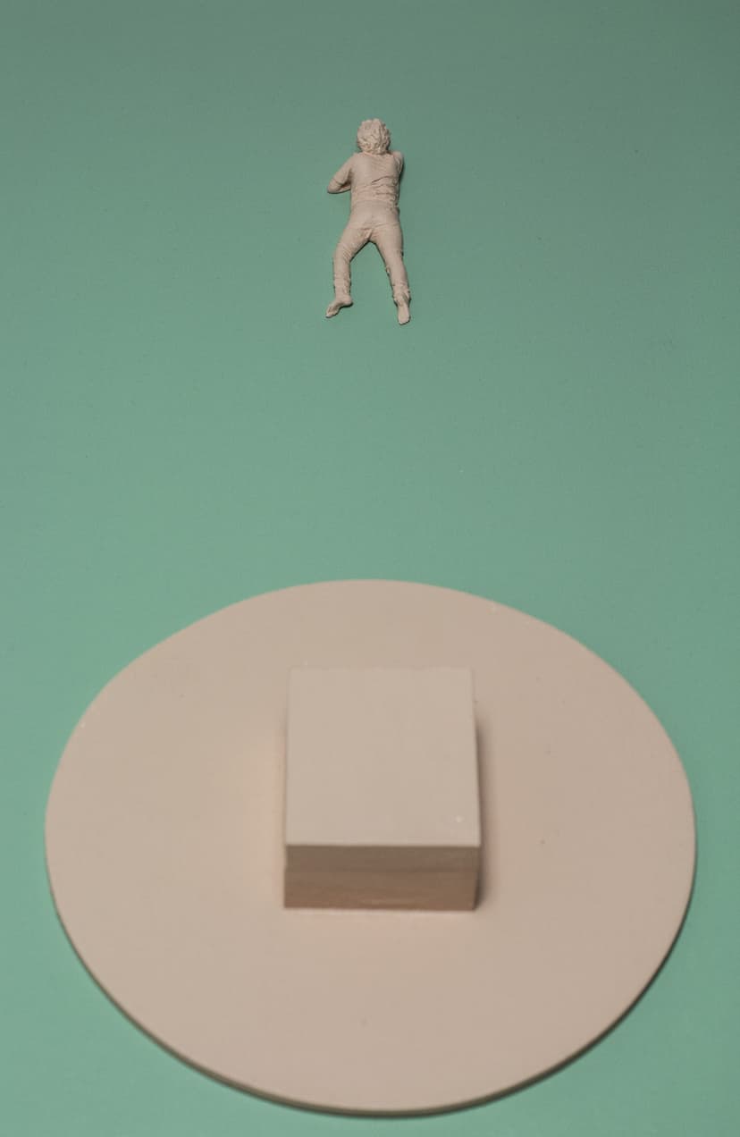 Detail of Mother by Federico Clapis: a pink resin figure lying on a mint green canvas above a pink disc with a small block