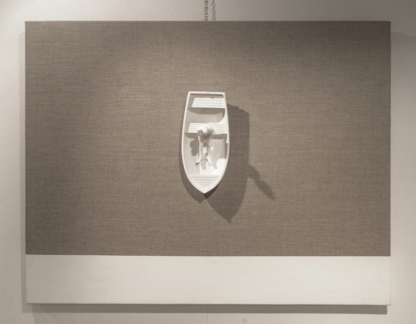 Not Knowing by Federico Clapis: grey linen canvas with a white rowing boat seen from above, a seated figure inside casting a long shadow
