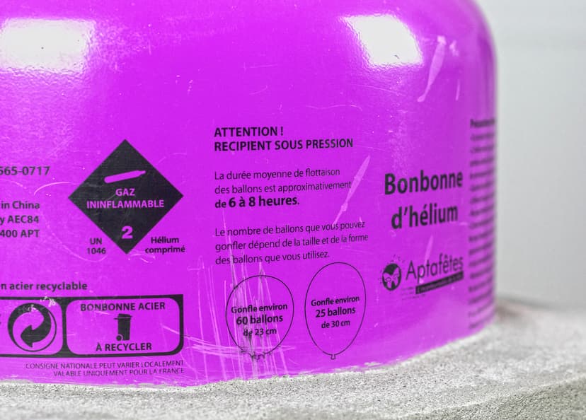 Detail of Self Portrait by Federico Clapis: French warning labels on a purple helium canister sitting on a grey concrete block