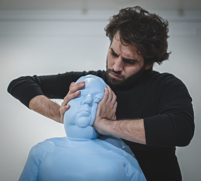 Close-up of Taboo: Federico Clapis presses the soft light blue polymer head of the sculpture, deforming its face