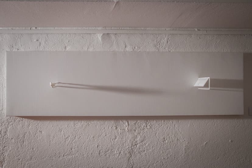 The Door by Federico Clapis: long white canvas on a rough wall, a tiny figure at one end facing a small open door at the other