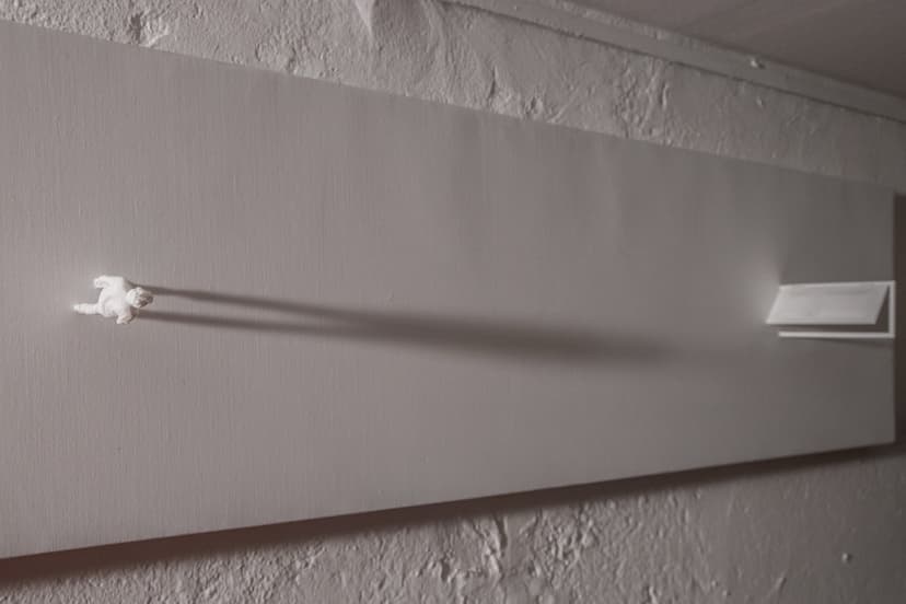 Angled view of The Door by Federico Clapis: a small white figure casts a long shadow toward a half-open door on the white canvas