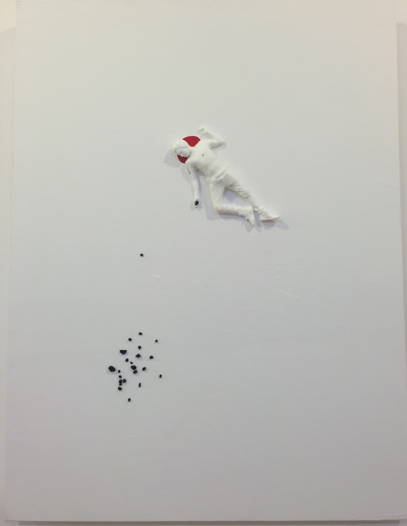 Full view of The End by Federico Clapis: white relief of a fallen man with a red disc by his head and a scatter of black stones