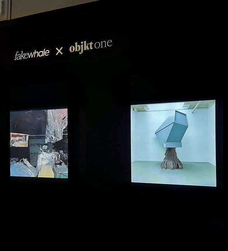 Fakewhale x objkt one booth at Art Dubai with two large screens, the right one showing a Federico Clapis sculpture of a box on a tree trunk