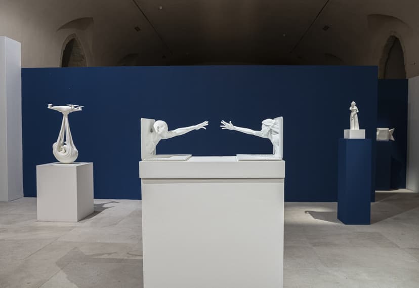 Touch Scream, two figures reaching out of laptops, between Babydrone and other white sculptures by Federico Clapis at Contact Zone, EXMA