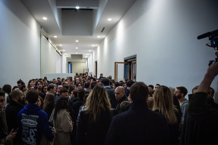 A large crowd of visitors fills a white corridor at Triennale Milano waiting to enter the Deep Scrolling Experience by Federico Clapis