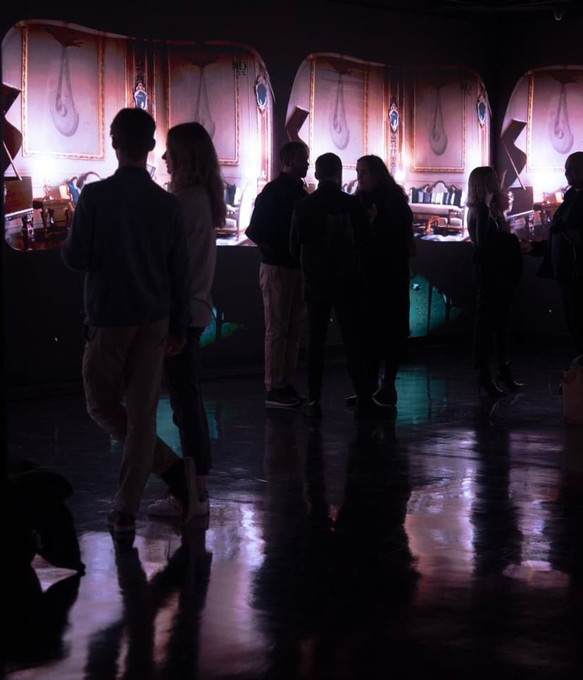 Visitors in silhouette before large projections of an ornate gilded interior at Disruption by W1 Curates in London, which included Federico Clapis