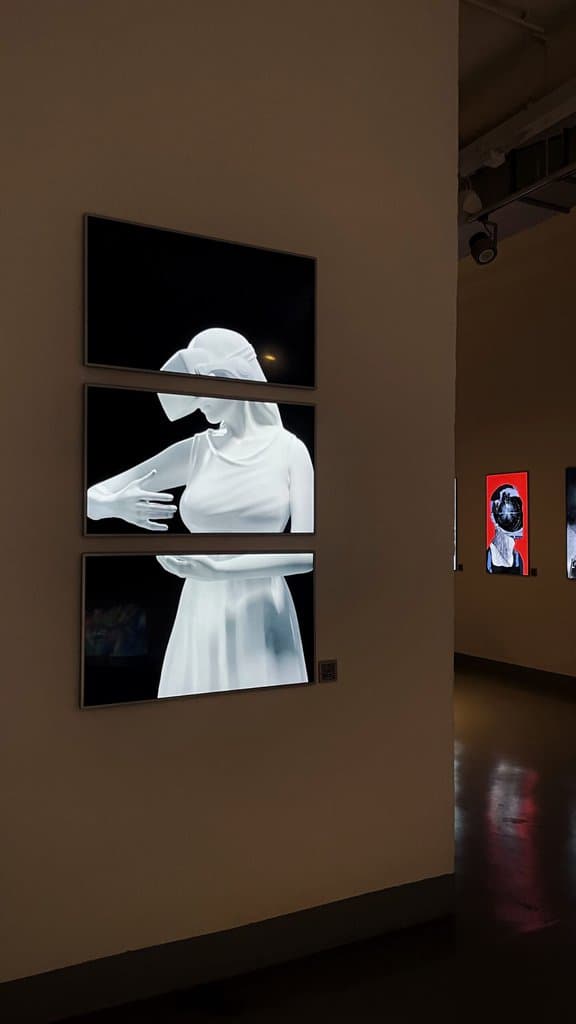 Federico Clapis' video work on three stacked screens, a white draped female figure, at Italy's Finest in the NINFA Labs gallery in Milan
