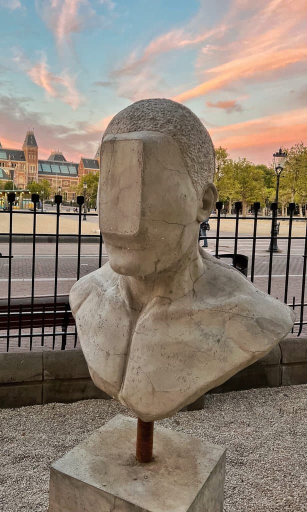 Concrete bust with a rectangular slab covering the eyes, by Federico Clapis, in the garden of Moco Museum Amsterdam on Museumplein
