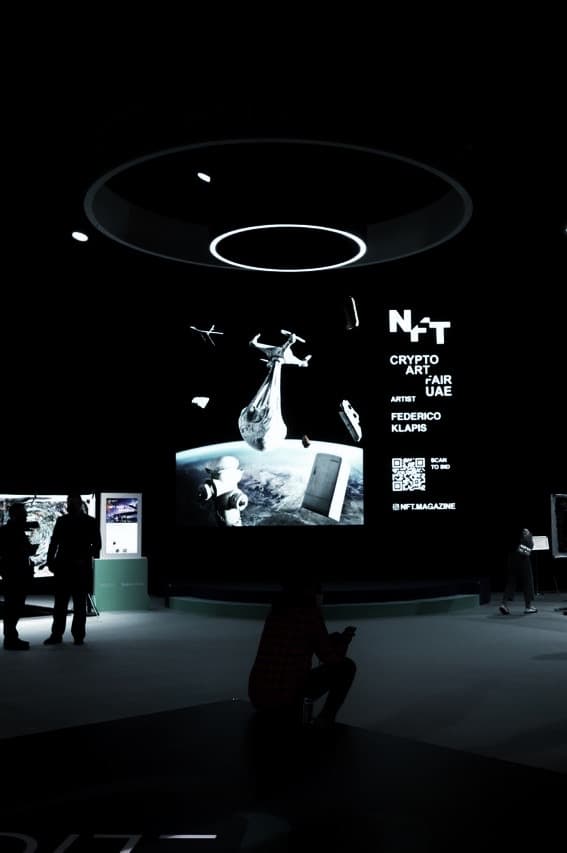 Federico Clapis' animation of a drone carrying a baby above the Earth on the large LED screen of the NFT Crypto Art Fair UAE, Abu Dhabi