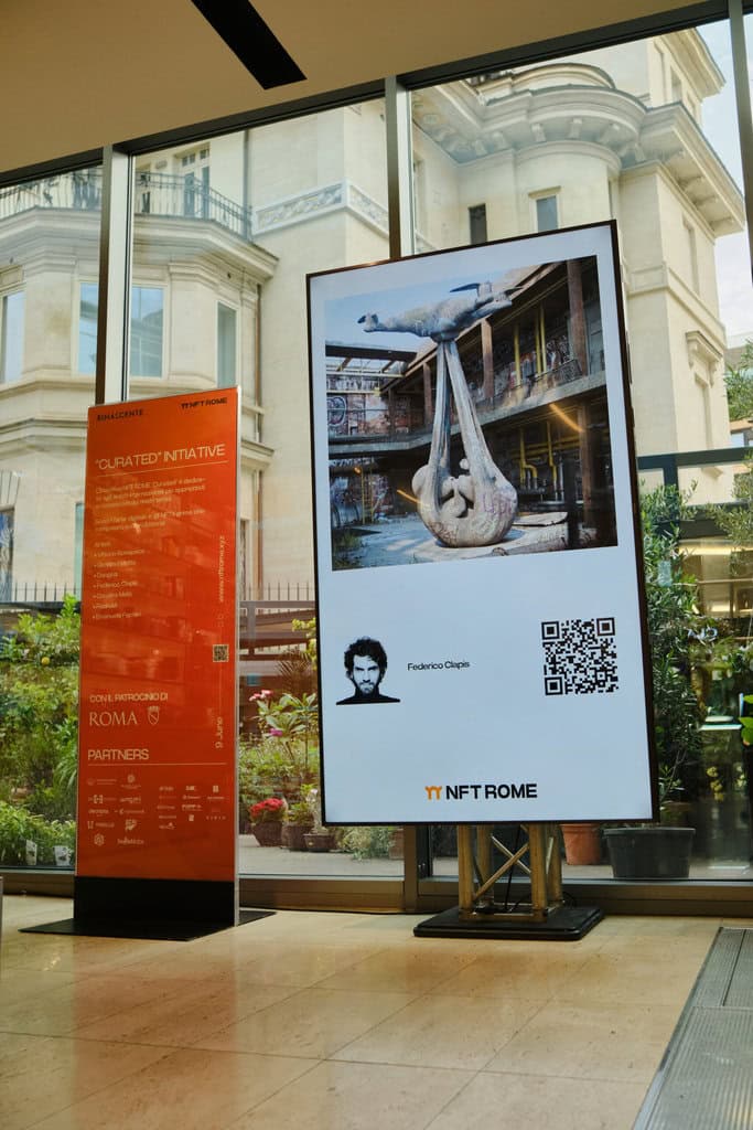 Inside La Rinascente in Rome, a vertical screen shows Federico Clapis' portrait and a drone sculpture beside the NFT Rome Curated totem