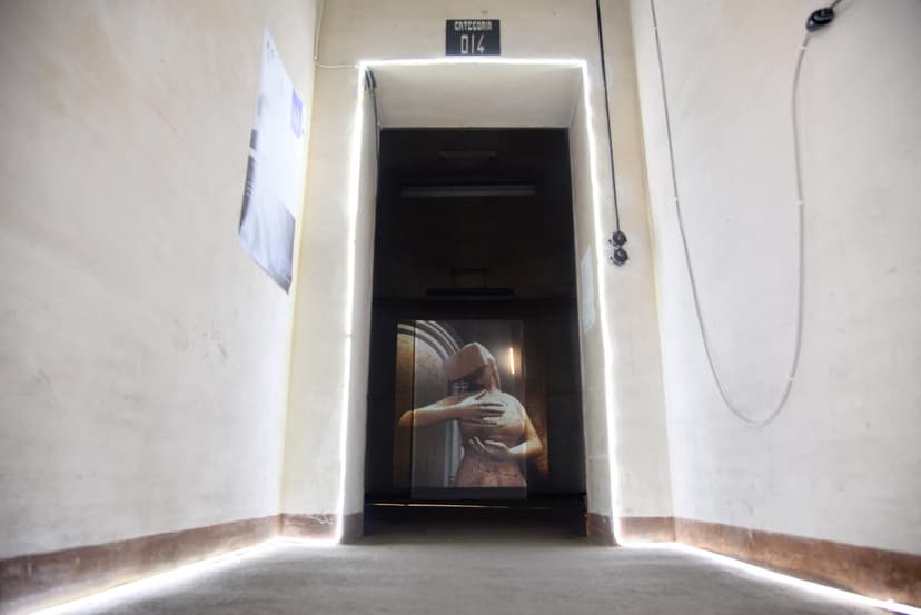 Doorway outlined by light strips in Scalo Vallino, Turin, framing a screen with a digital female figure in a VR headset by Federico Clapis