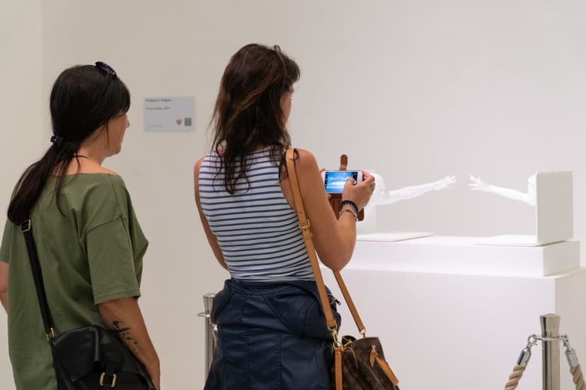 Visitors film Touch Scream by Federico Clapis at Triennale Milano: two figures emerging from laptops, behind rope barriers, wall label beside